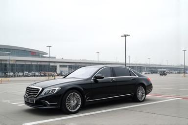 Luxury car waiting at an airport pickup zone.